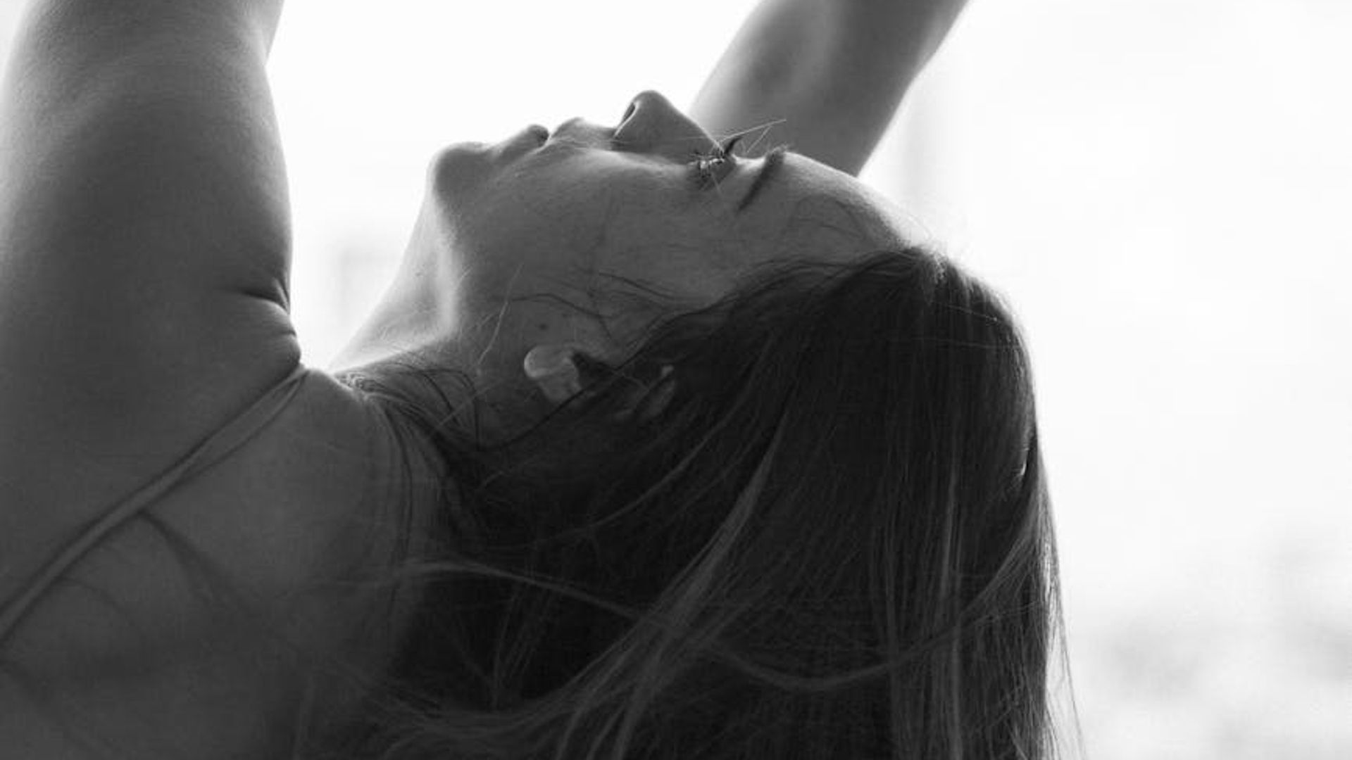 Abstract silhouette of a person in a dynamic yoga pose.